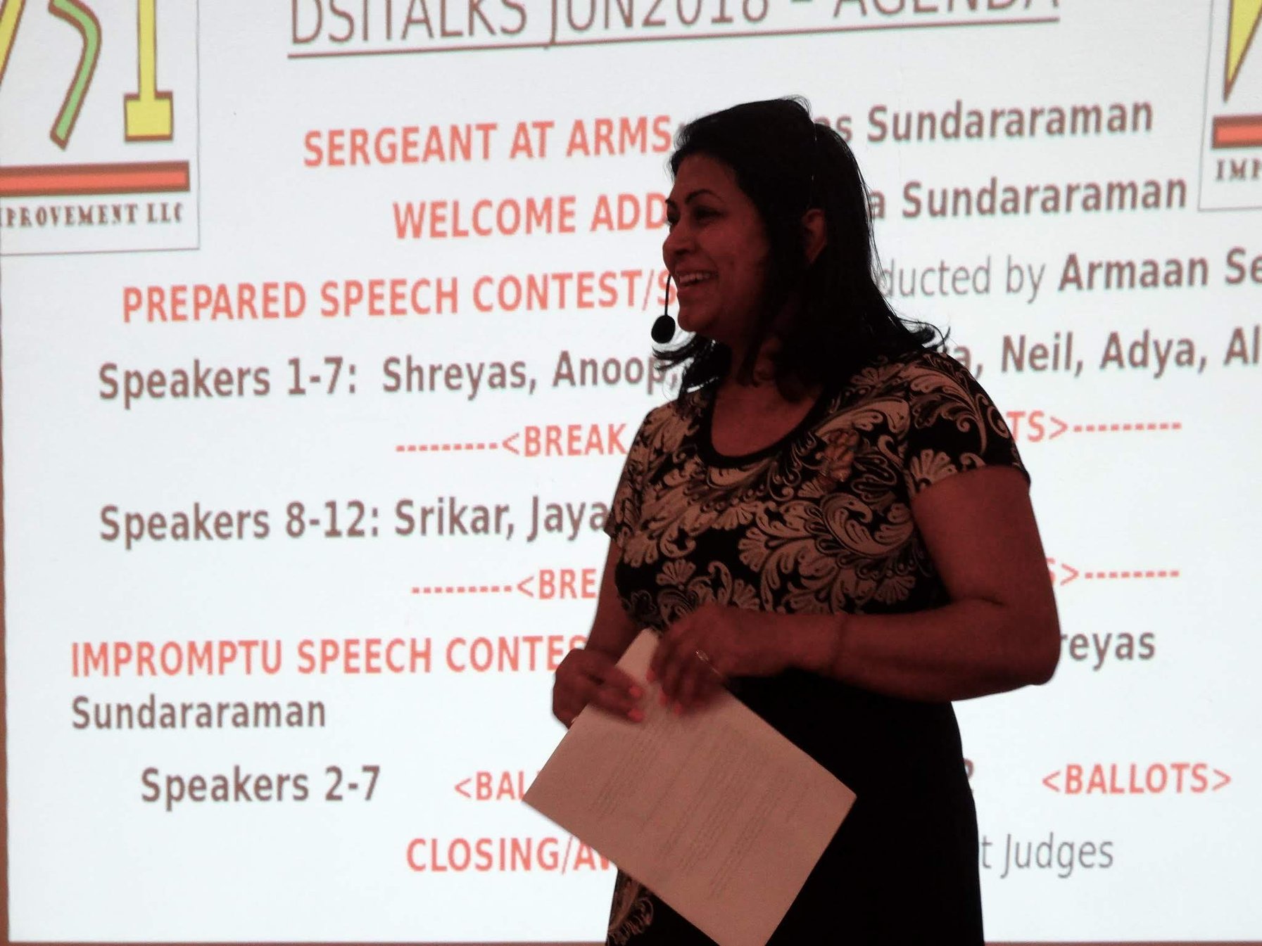 Coach Priya Sundararaman speaking with a headset microphone in front of a projected DSITalks June 2018 agenda slide